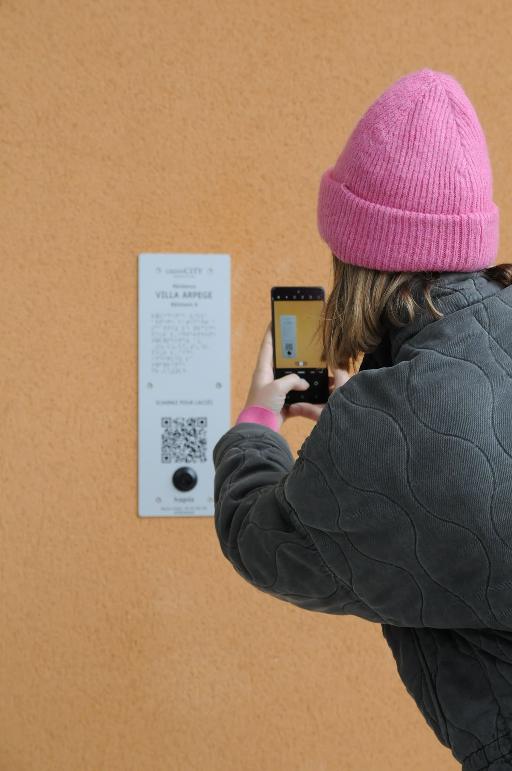 Personne qui, à l'aide de son téléphone, scanne le qr code d'une plaque hapiix.