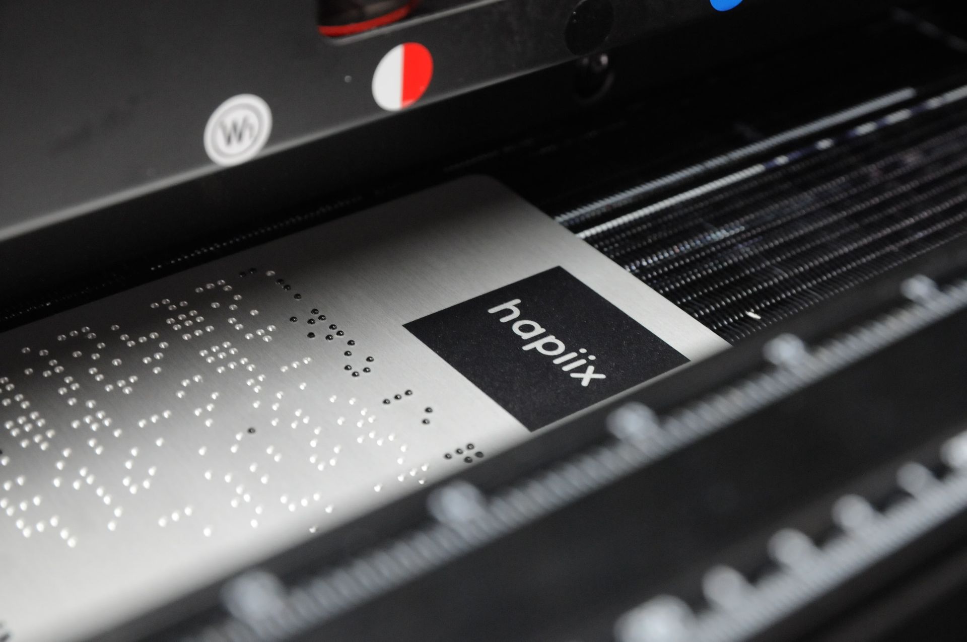 Photo d'une fabrication de la plaque hapiix mettant en avant l'inscription en braille.