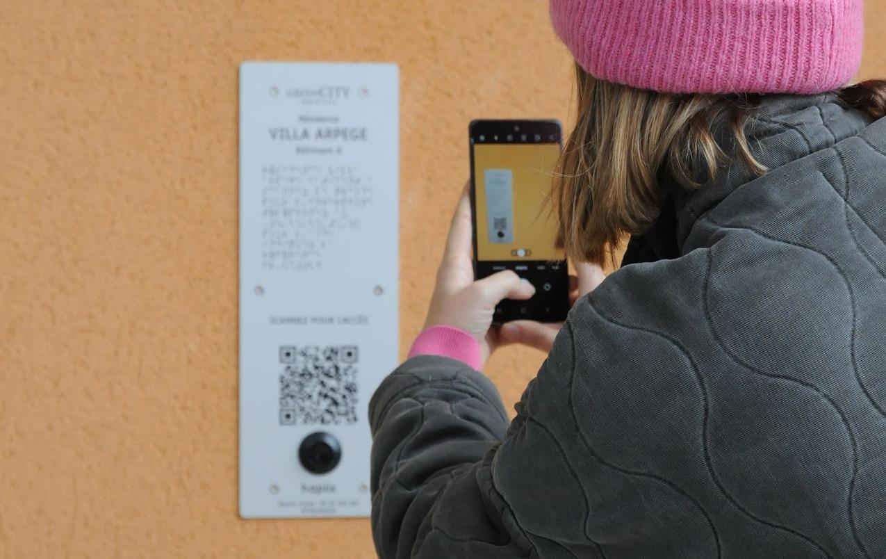 Personne qui, à l'aide de son téléphone, scanne le qr code d'une plaque hapiix.