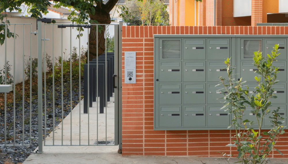 Photo montrant la plaque hapiix installée au niveau d'un portillon d'entrée de résidence.