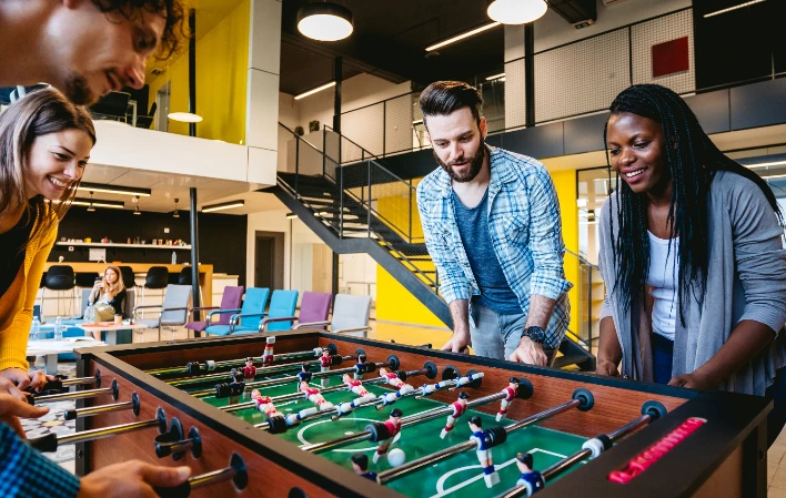 Photo de plusieurs étudiants qui partagent un moment convivial autour d'une partie de babyfoot